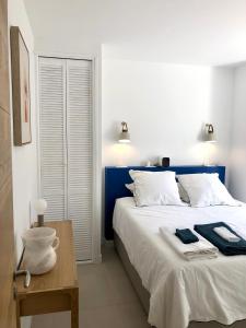 Un dormitorio con una gran cama blanca con detalles azules. en San Estello, en Sanary-sur-Mer