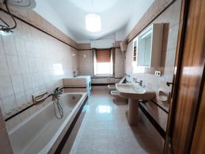 ein Badezimmer mit Badewanne und Waschbecken in der Unterkunft 5 Stars - SEA FRONT APARTMENTS in Marina di Strongoli