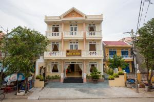 a large yellow house with a balcony at Han Huyen Homestay in Hoi An