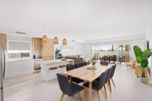 een keuken en eetkamer met een houten tafel en stoelen bij HideAway I at Shoal Bay in Shoal Bay