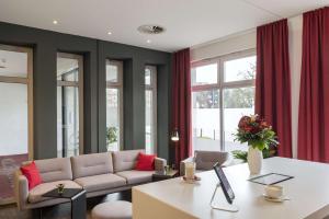 a living room filled with furniture and a window at NH Collection Hamburg City in Hamburg