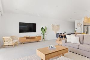 a living room with a couch and a tv at HideAway I at Shoal Bay in Shoal Bay