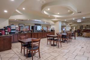 a restaurant with tables and chairs and a counter at BEST WESTERN PLUS Monica Royale Inn & Suites in Greenville