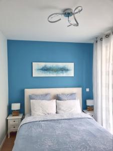 Dormitorio azul con cama y pared azul en BELQUIS, en Chessy