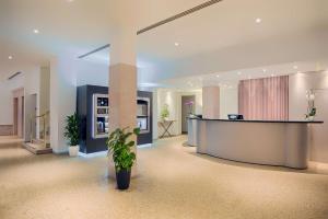 a lobby with a reception desk and a potted plant at NH Ravenna in Ravenna