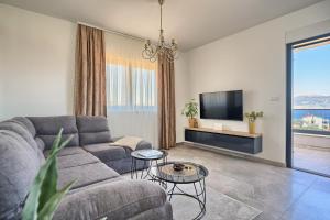 a living room with a couch and a tv at Doris' Place - sea view flat close to beach in Slatine