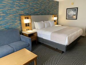 a hotel room with a bed, chair, and nightstand at Radisson Hotel Niagara Falls-Grand Island in Grand Island