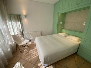 a bedroom with a white bed and a window at Casa do Zimbro in Troia