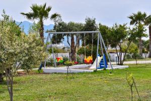 a playground with a swing set in a park at LambiSea Apartment 2 in Kos