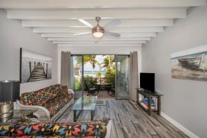 uma sala de estar com um sofá e uma ventoinha de tecto em Beach Living at Villas Pappagallo (BLPP) em West Bay