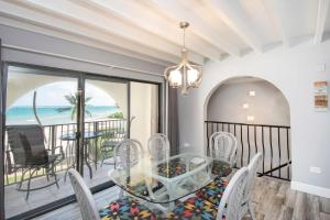 West Bay的住宿－Beach Living at Villas Pappagallo (BLPP)，一间设有玻璃桌和椅子的用餐室