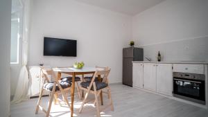 una cucina con tavolo, sedie e TV di Max suite a Trogir