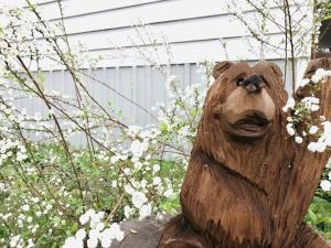 a wooden bear statue sitting in a garden at Sierra Mountain Lodge - Vacation Rentals - Yosemite in Ahwahnee