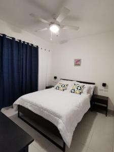 una camera con letto e ventilatore a soffitto di Vista Golf Playa Nueva Romana a La Romana