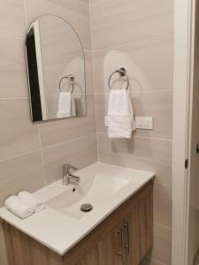 een badkamer met een witte wastafel en een spiegel bij Vista Golf Playa Nueva Romana in La Romana