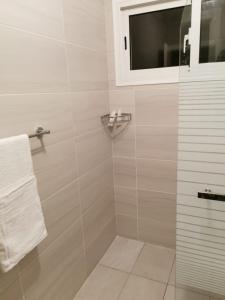 a bathroom with a shower with a window and white towels at Vista Golf Playa Nueva Romana in La Romana