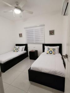 1 dormitorio con 2 camas y sofá en Vista Golf Playa Nueva Romana, en La Romana