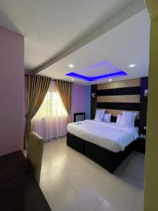 una camera da letto con un grande letto e un soffitto blu di Alluring View Hotel - Allen Avenue a Lagos