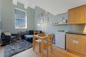 a kitchen and living room with a couch and a table at Duplex 3 Bedroom Mezzanine Apartment - Heart of Edinburgh in Edinburgh