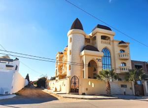 ein Gebäude mit einem Turm auf der Seite in der Unterkunft Mahdia - Baghdadi - Laourient Apartments, restaurant, café in Mahdia