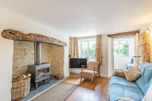 a living room with a blue couch and a fireplace at Hillside Cottage in Bridgwater