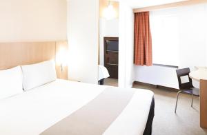 1 dormitorio con cama, escritorio y silla en ibis Birmingham Centre New Street Station Hotel, en Birmingham