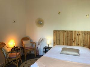 a bedroom with a white bed and two chairs at Studio paisible avec jardin - Tours centre in Tours