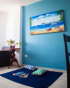 una camera con una parete blu con l'immagine di una spiaggia di La Mochila SM a Santa Marta