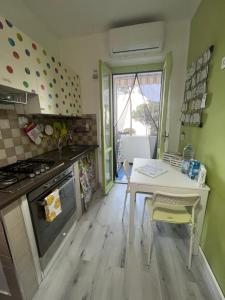 a kitchen with a table and a stove and a table and chairs at Appartamento Affaccio sul mare, Baia di Copanello in Copanello +26 photos