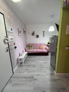 een woonkamer met een roze bank en een koelkast bij Appartamento Affaccio sul mare, Baia di Copanello in Copanello