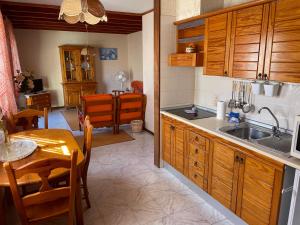 a kitchen with wooden cabinets and a table and a dining room at Parque Holandés Fuerteventura casa Mayte in La Oliva