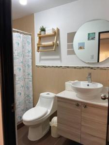 La salle de bains est pourvue de toilettes, d'un lavabo et d'un miroir. dans l'établissement Wave nSea Monterrico, à Monterrico