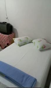 ピレノポリスにあるSuítes São Judasのベッドの上に座った枕2つ