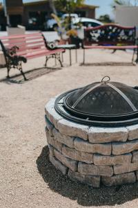 una hoguera de piedra en un parque con un banco en Sea Air Inn & Suites - Downtown - Restaurant Row, en Morro Bay