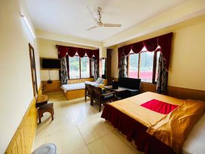 a bedroom with a bed and a desk and a chair at Hotel Snow Mountain Mall Road in Manāli