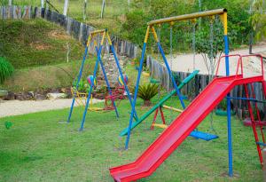 a playground with colorful swings in a yard at Pousada Brilho do Sol in Serra Negra