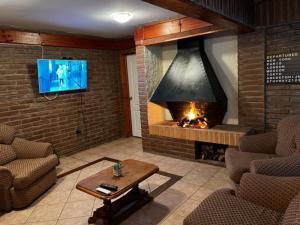 a living room with a fireplace and a tv at Linda Casa en Barrio Residencial la Herradura Oriente a 5 min playa in Coquimbo