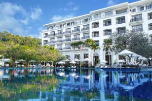 um hotel com piscina em frente a um edifício em The Danna Langkawi - A Member of Small Luxury Hotels of the World em Pantai Kok