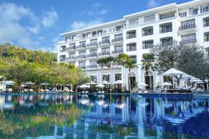 ein Hotel mit einem Swimmingpool vor einem Gebäude in der Unterkunft The Danna Langkawi - A Member of Small Luxury Hotels of the World in Pantai Kok