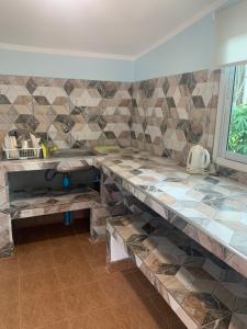 a kitchen with a counter with a sink and tiles at NADOHN2 San Fan Homestay in Rayong