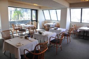 uma sala de jantar com mesas, cadeiras e janelas em City Park Hotel em Melbourne