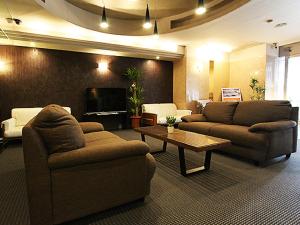 ein Wohnzimmer mit 2 Sofas und einem Couchtisch in der Unterkunft HOTEL LiVEMAX BUDGET Kobe in Kōbe
