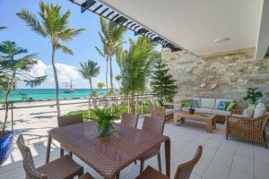 a patio area with chairs, tables and umbrellas at Costa Atlantica Beach Condo in Punta Cana
