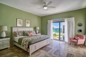a bedroom with a bed, a chair, and a window at Costa Atlantica Beach Condo in Punta Cana
