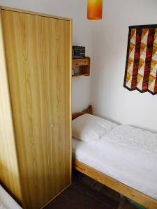 a small bedroom with a bed and a wooden door at Ferienwohnung Plexnies in Kellenhusen