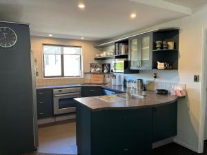 a kitchen with black cabinets and a sink at Family Home on Inverness in Arrowtown