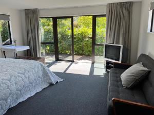 a bedroom with a bed and a flat screen tv at Family Home on Inverness in Arrowtown