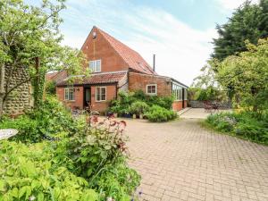 a house with a brick driveway in front of it at The Hermitage in Holt