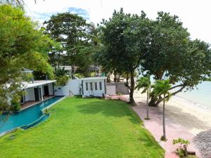 a green and white house on a lush green hillside at Yao Yai Beach Resort in Ko Yao Yai