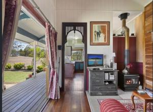 a living room with a wooden deck with a stove at Barney Creek Vineyard Cottages in Barney View